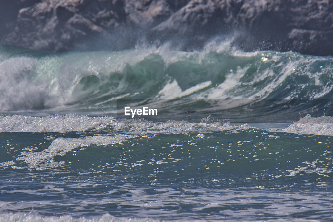 AERIAL VIEW OF SEA WAVES RUSHING TOWARDS SHORE