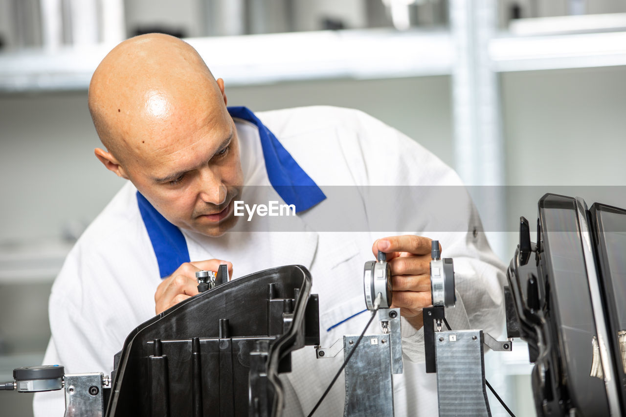 MAN LOOKING AT CAMERA IN OFFICE