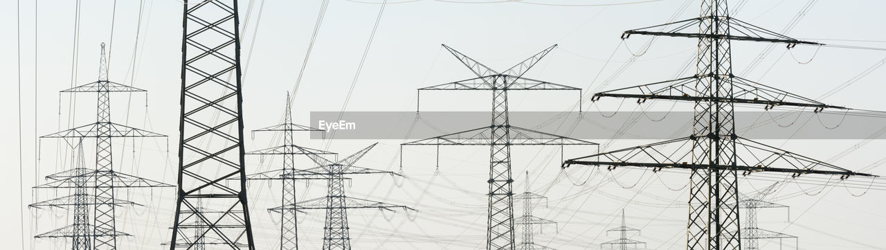 Panoramic view of electricity pylons against clear sky