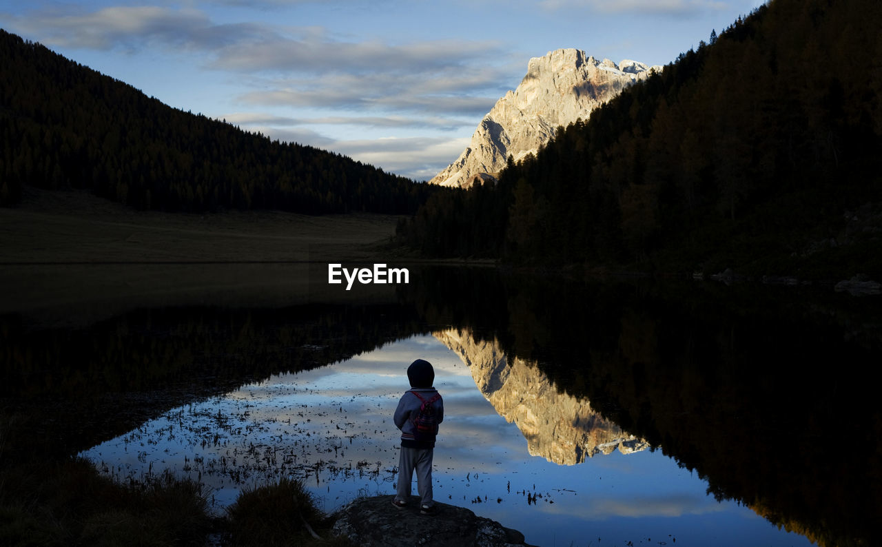 Sunny day on dolomites, boy looks at mountain