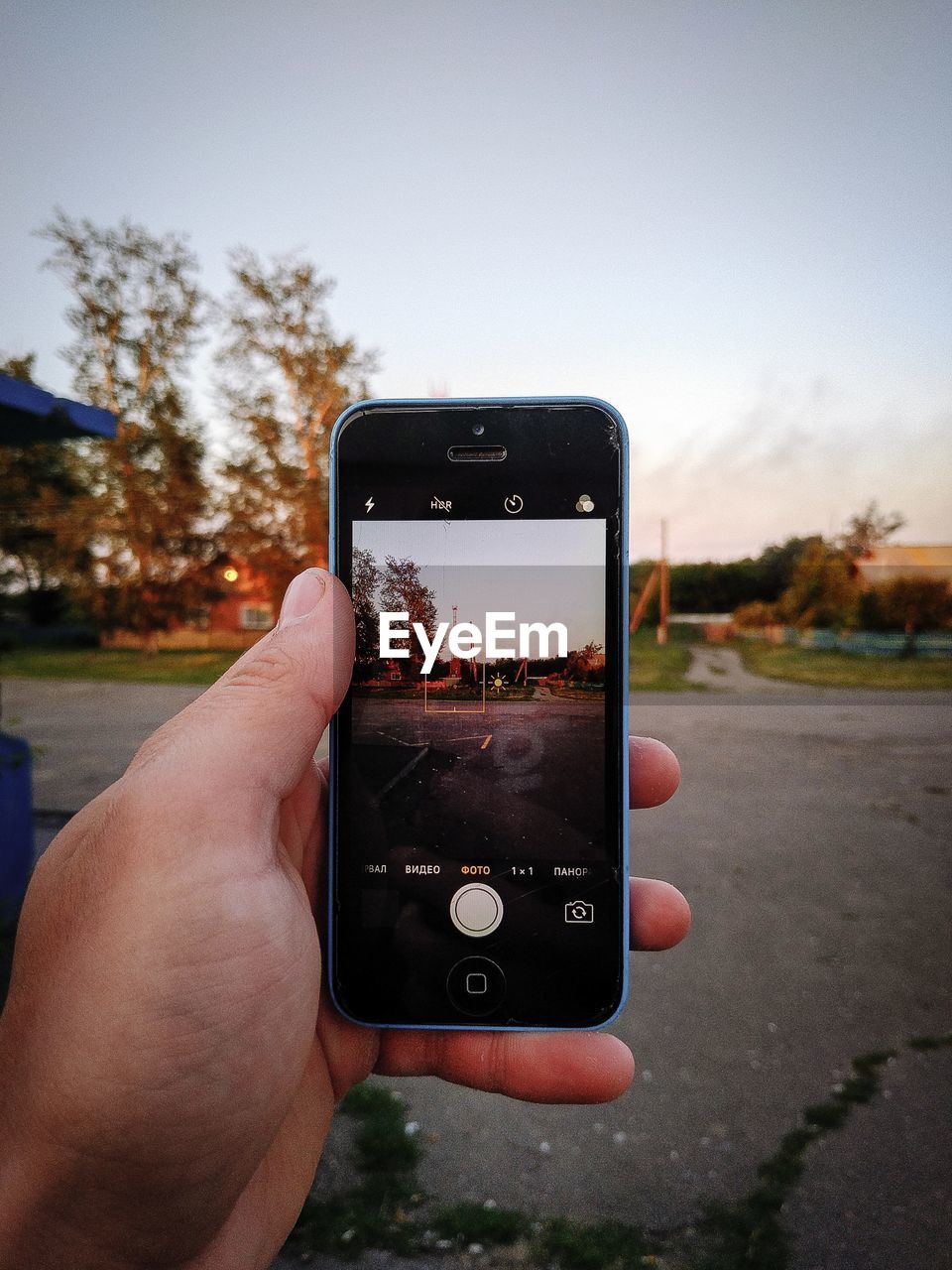 MIDSECTION OF PERSON USING MOBILE PHONE IN PARK