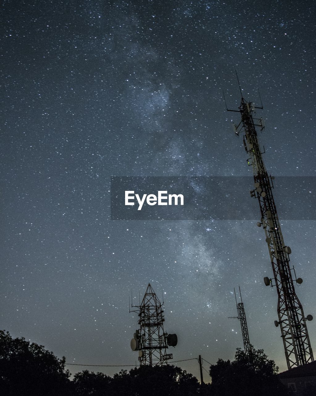 Low angle view of silhouette telecommunication tower against sky at night