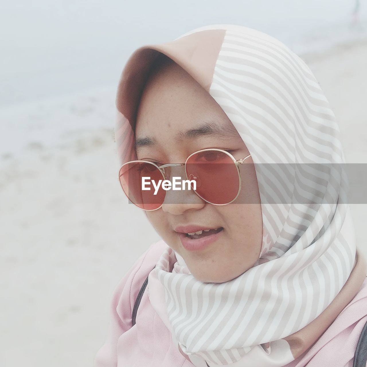 Close-up of young woman wearing sunglasses at beach