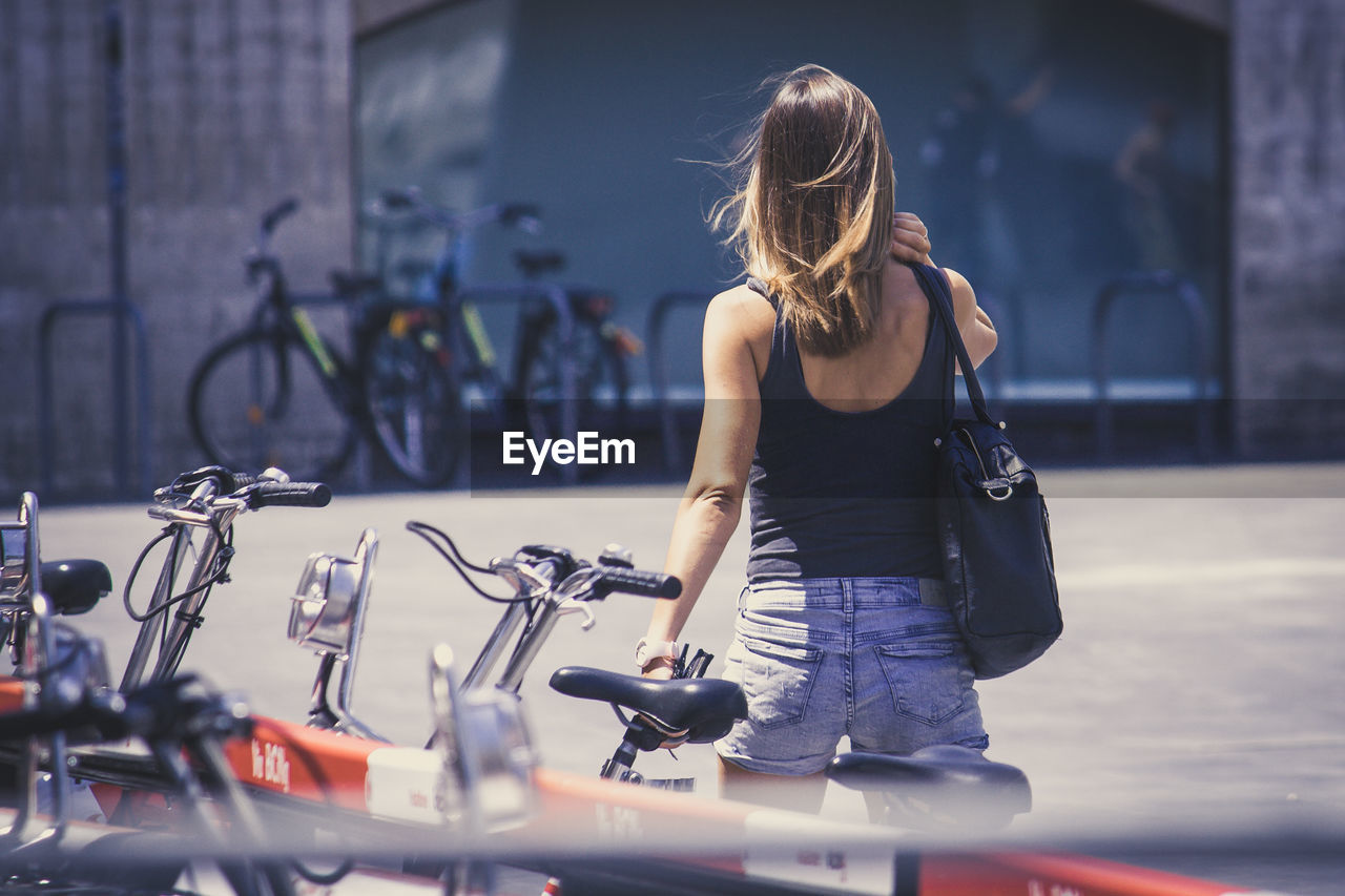 WOMAN WITH BICYCLE ON STREET