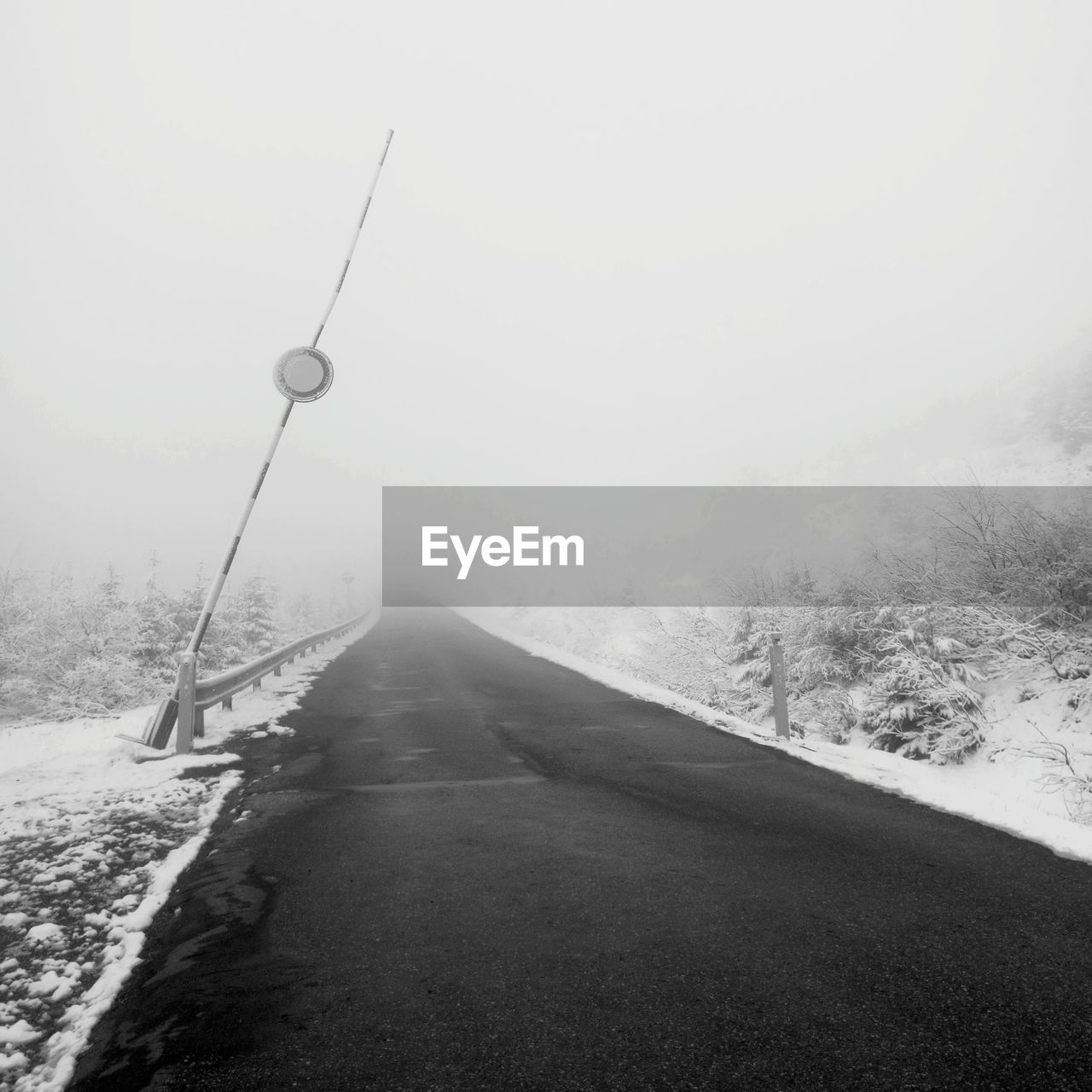 Road amidst snowcapped landscape against sky during winter