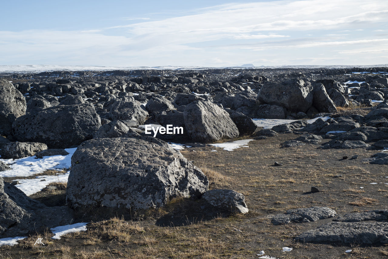 Rocks on land against sky during winter