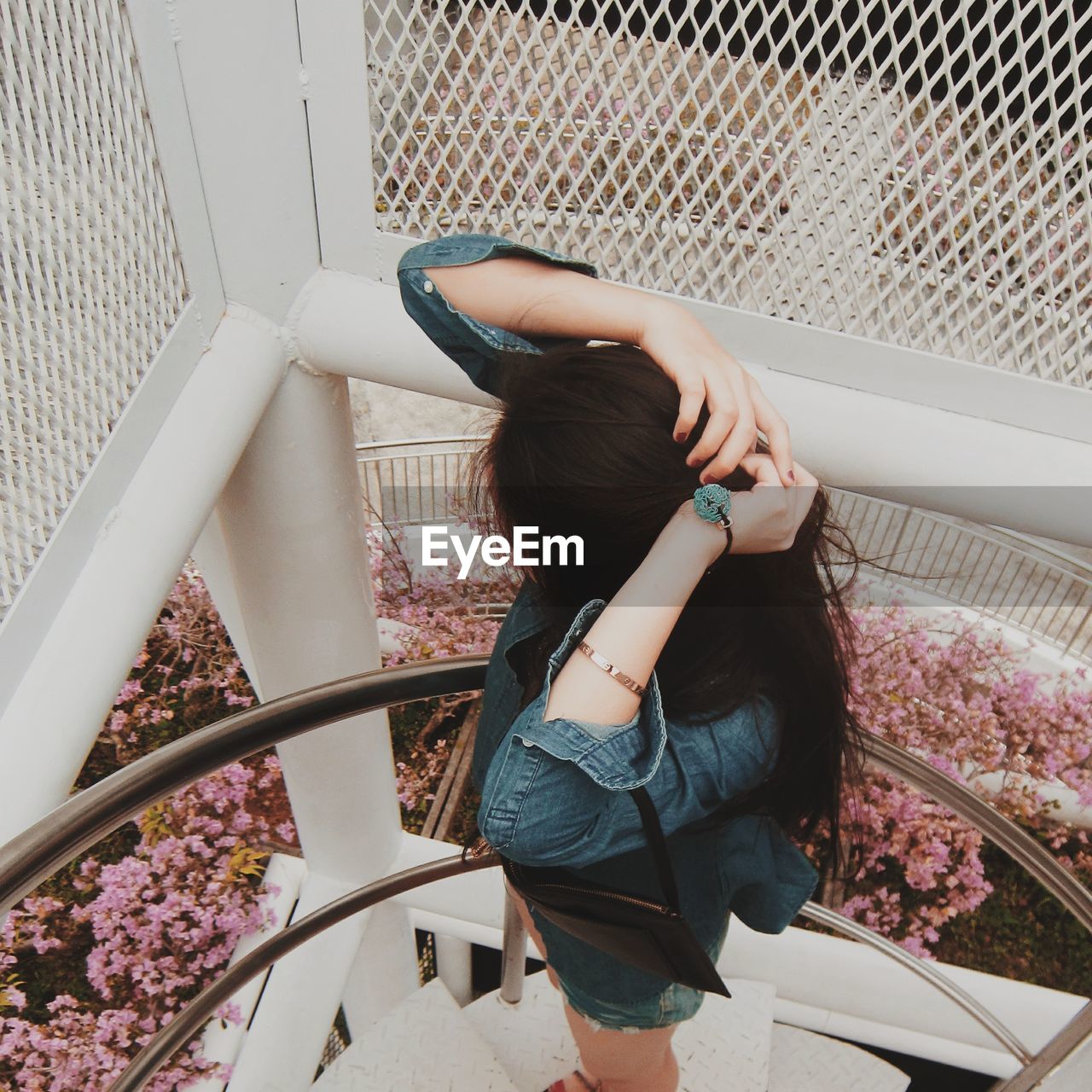 HIGH ANGLE VIEW OF WOMAN STANDING AT STAIRCASE