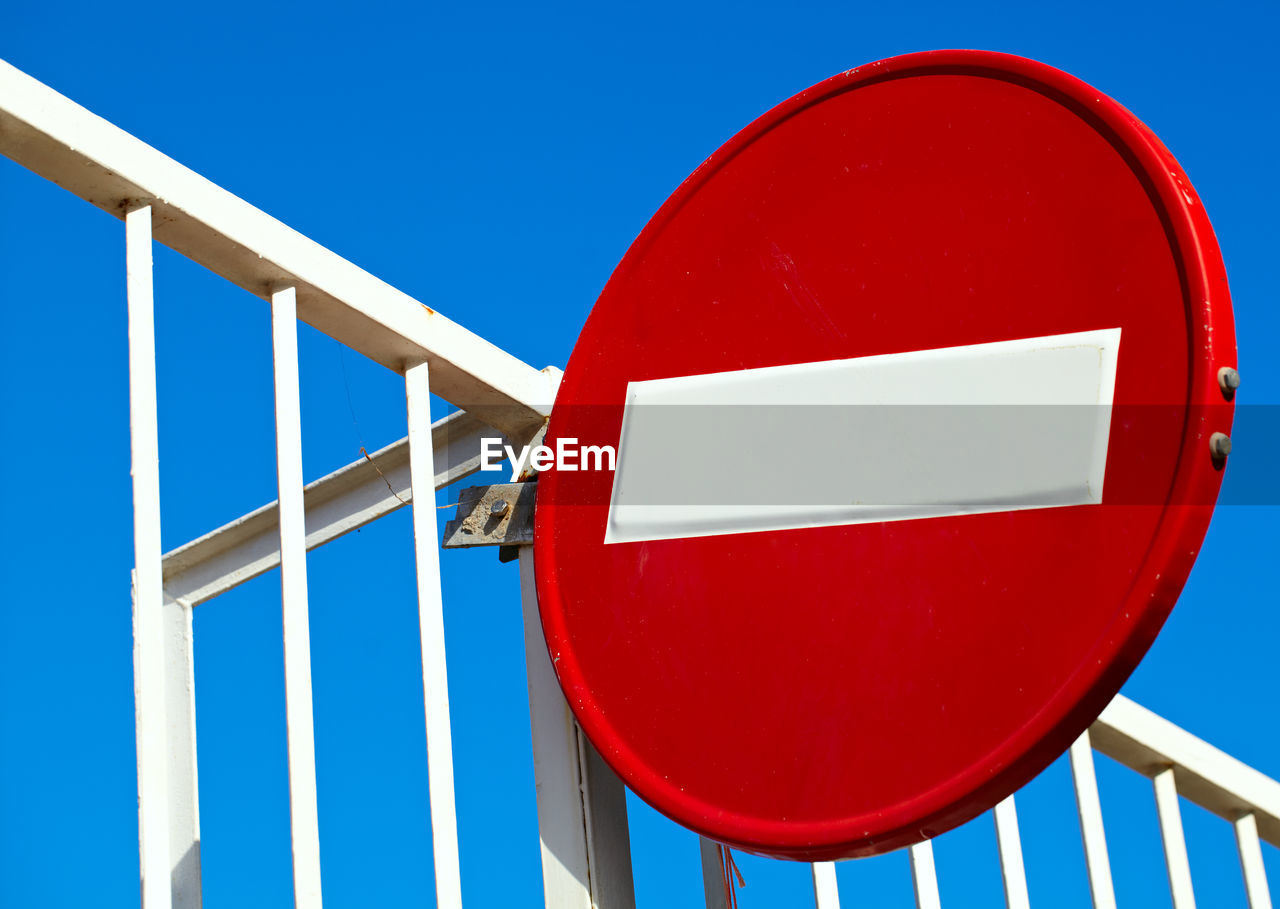 Low angle view of do not enter sign against clear blue sky