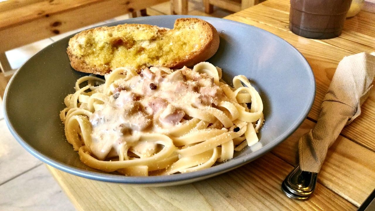 Pasta and bread in bowl on table
