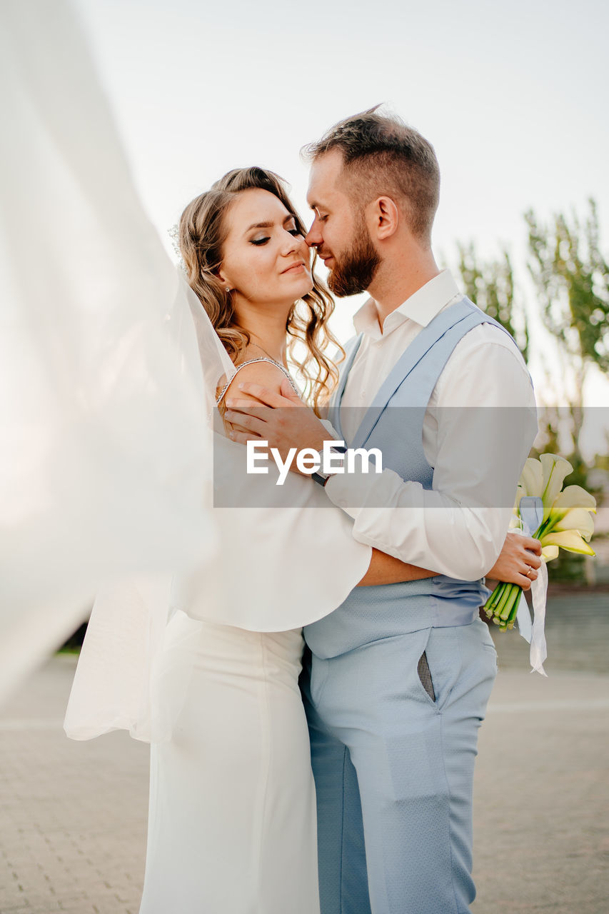 Couple embracing while standing outdoors