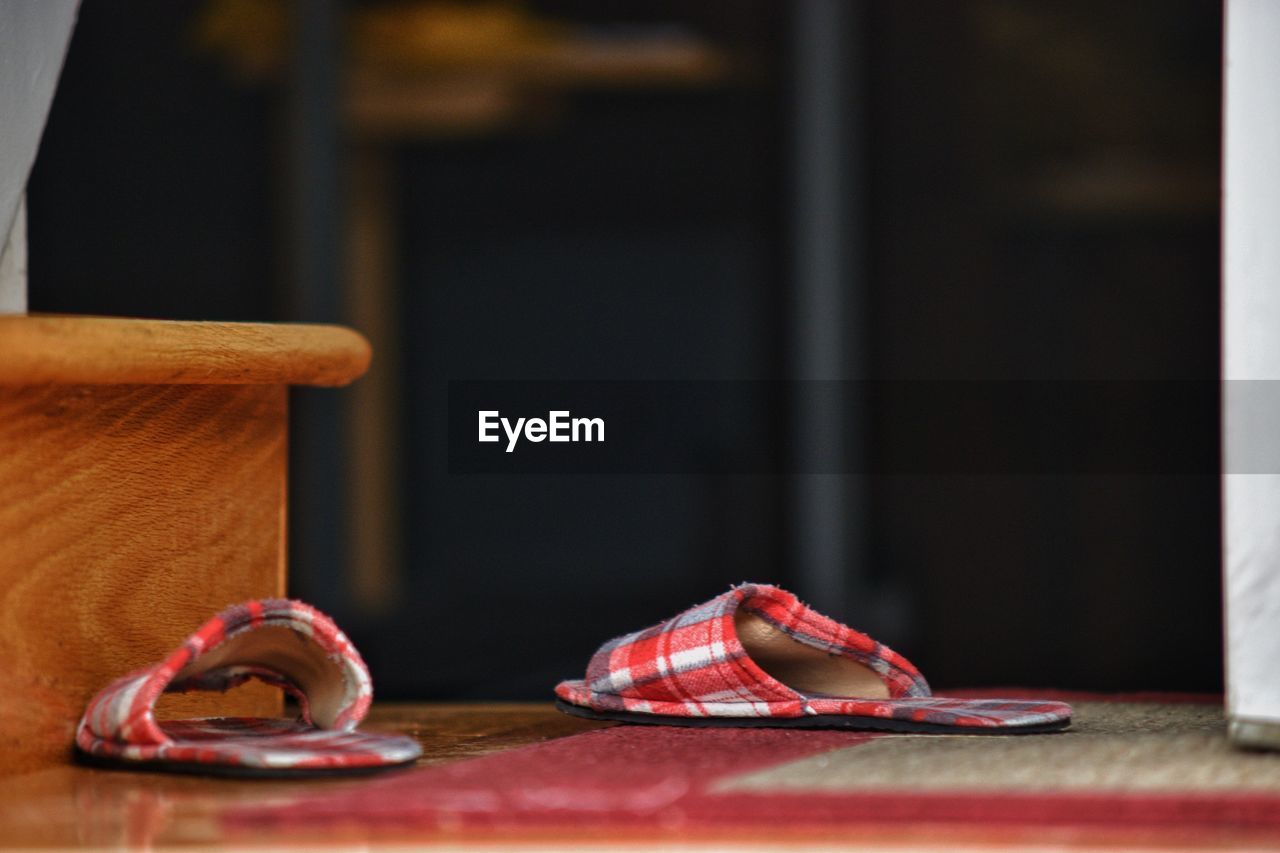 CLOSE-UP OF SHOES ON WOODEN TABLE