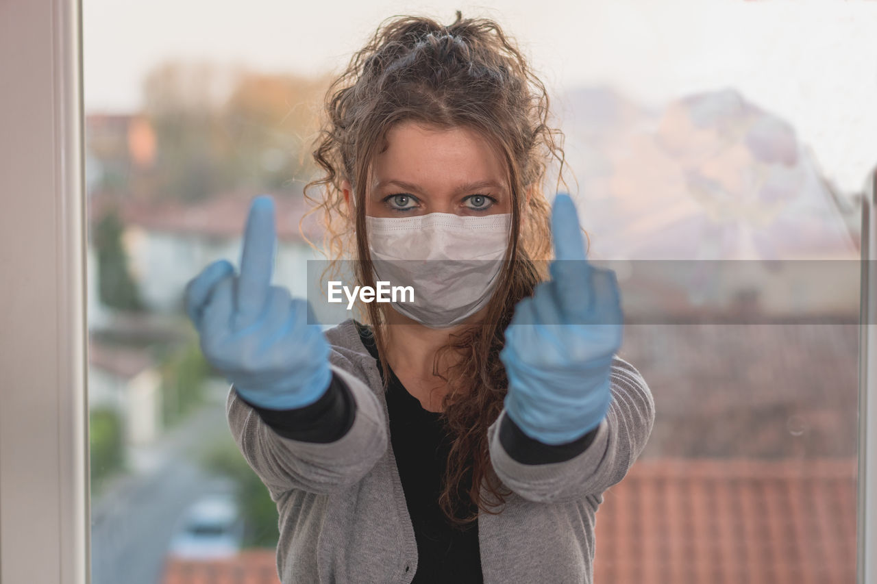 Portrait of a beautiful young woman wearing surgical mask and gloves 