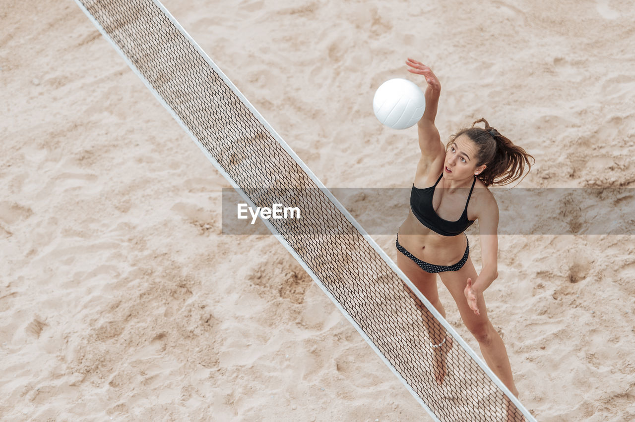 High angle view of woman playing with ball on beach