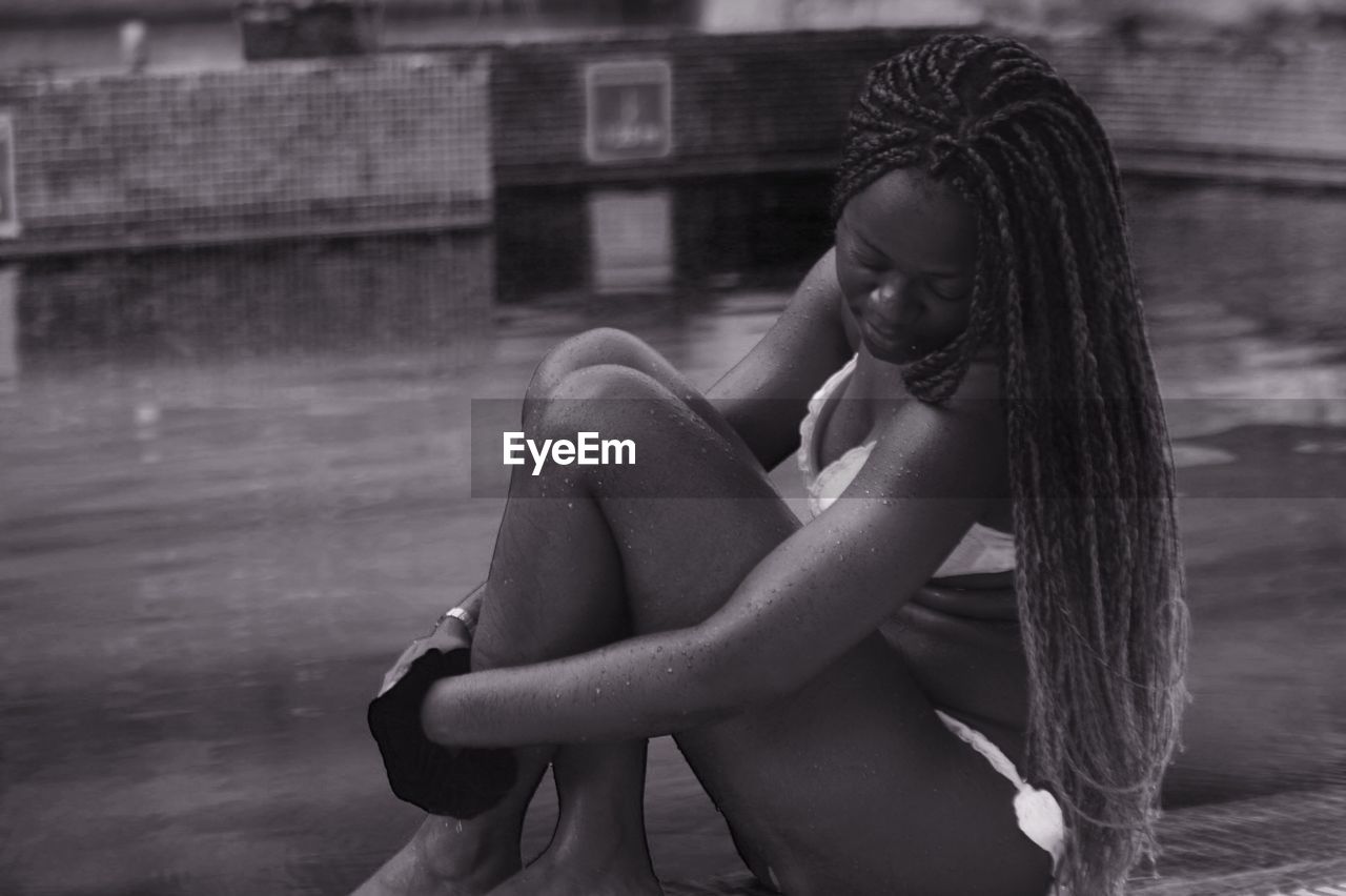 Young woman sitting poolside