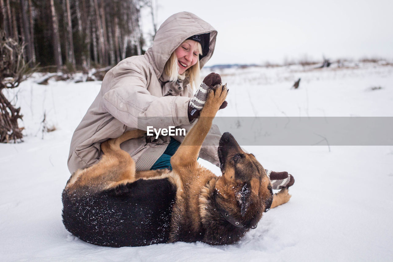 Young woman with dog on snow