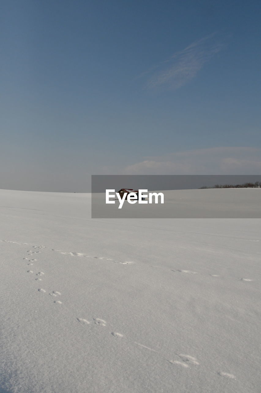 Scenic view of snow covered land against sky