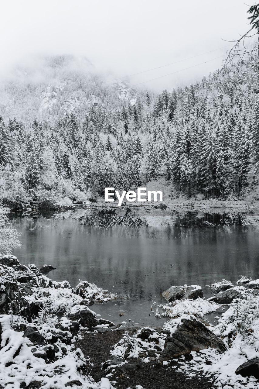 Scenic view of lake against sky during winter
