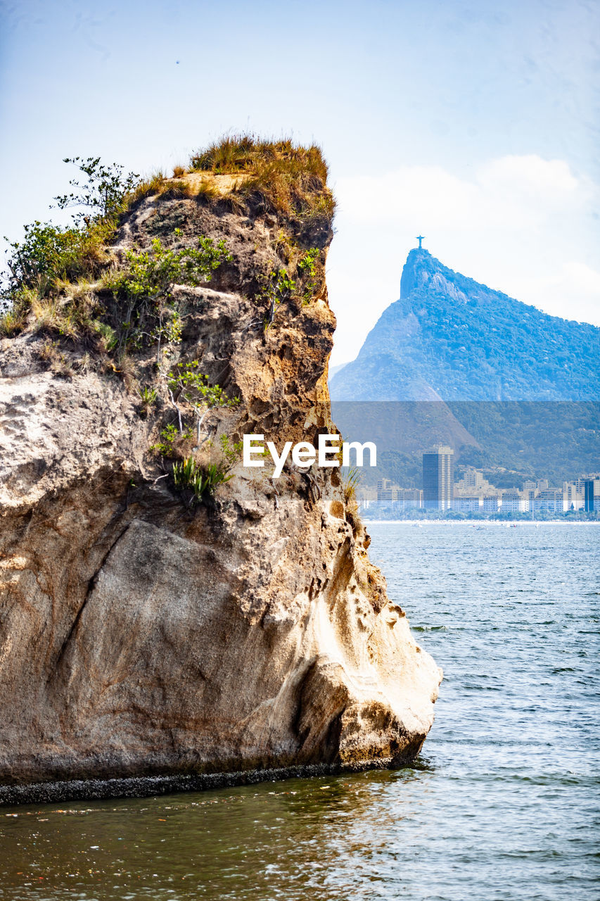 water, rock, sea, coast, nature, cliff, mountain, beauty in nature, scenics - nature, sky, land, ocean, travel destinations, landscape, shore, environment, terrain, travel, no people, rock formation, beach, bay, outdoors, coastline, day, blue, tranquility, reflection, tranquil scene, cloud, architecture, non-urban scene, tourism, mountain range, idyllic