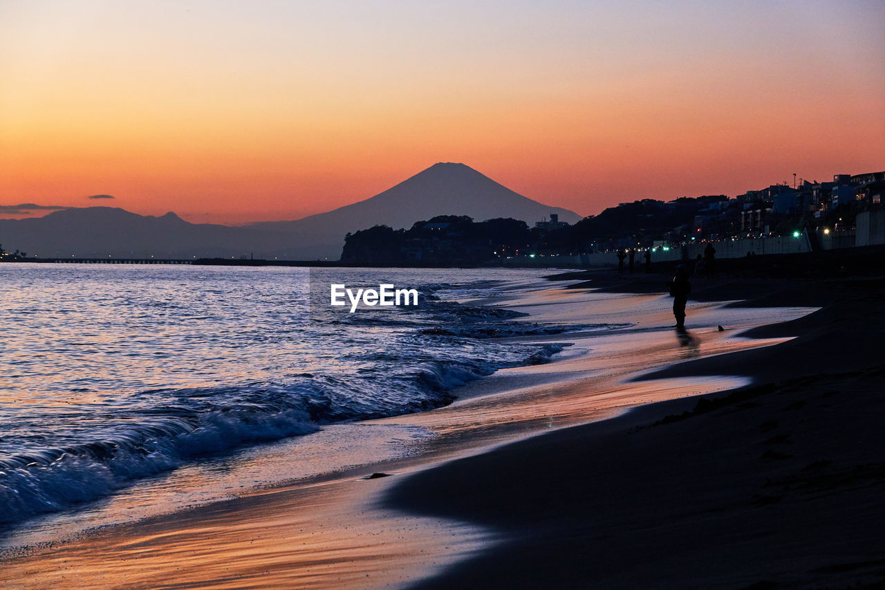 SCENIC VIEW OF BEACH AT SUNSET