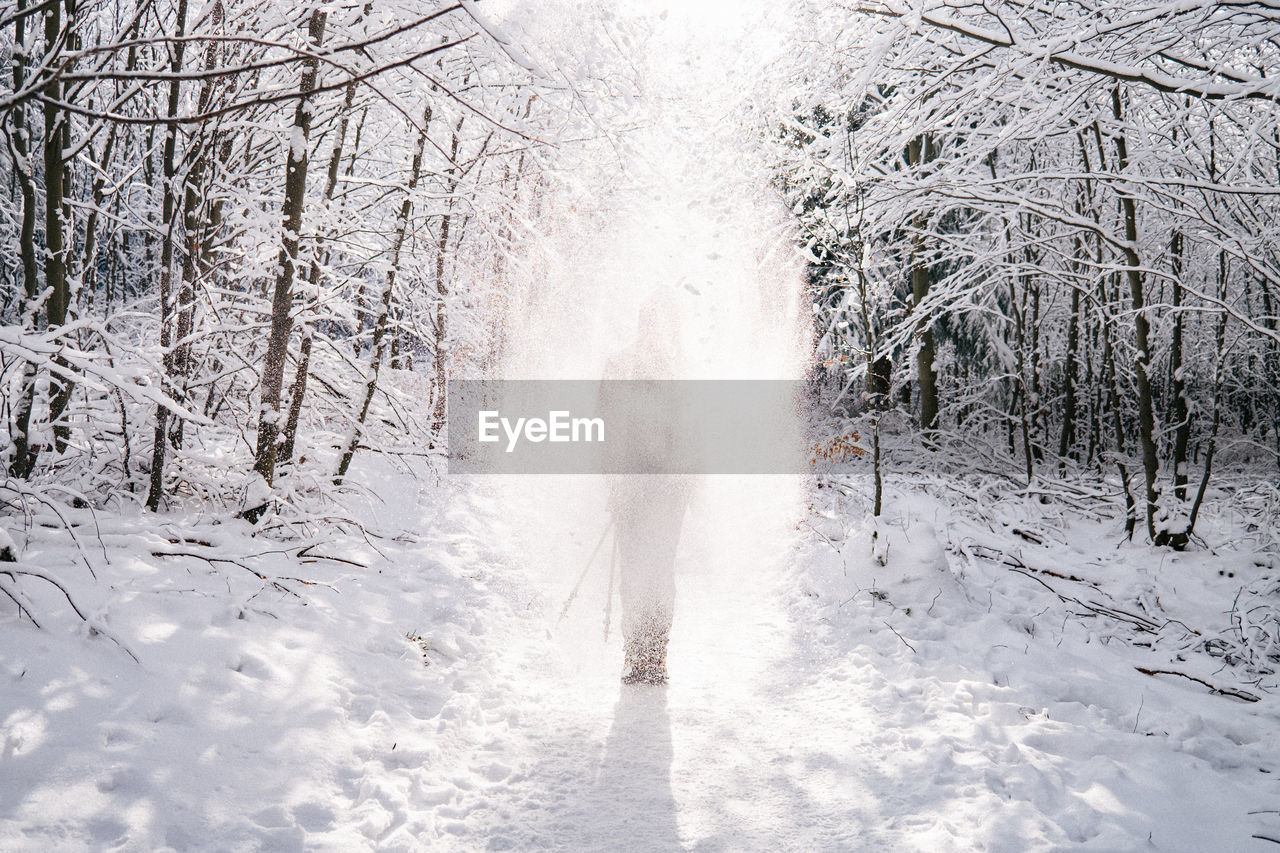 Woman standing on snow covered land during winter