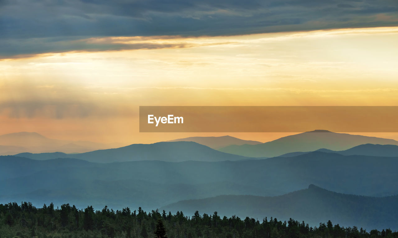 Scenic view of silhouette mountains against orange sky