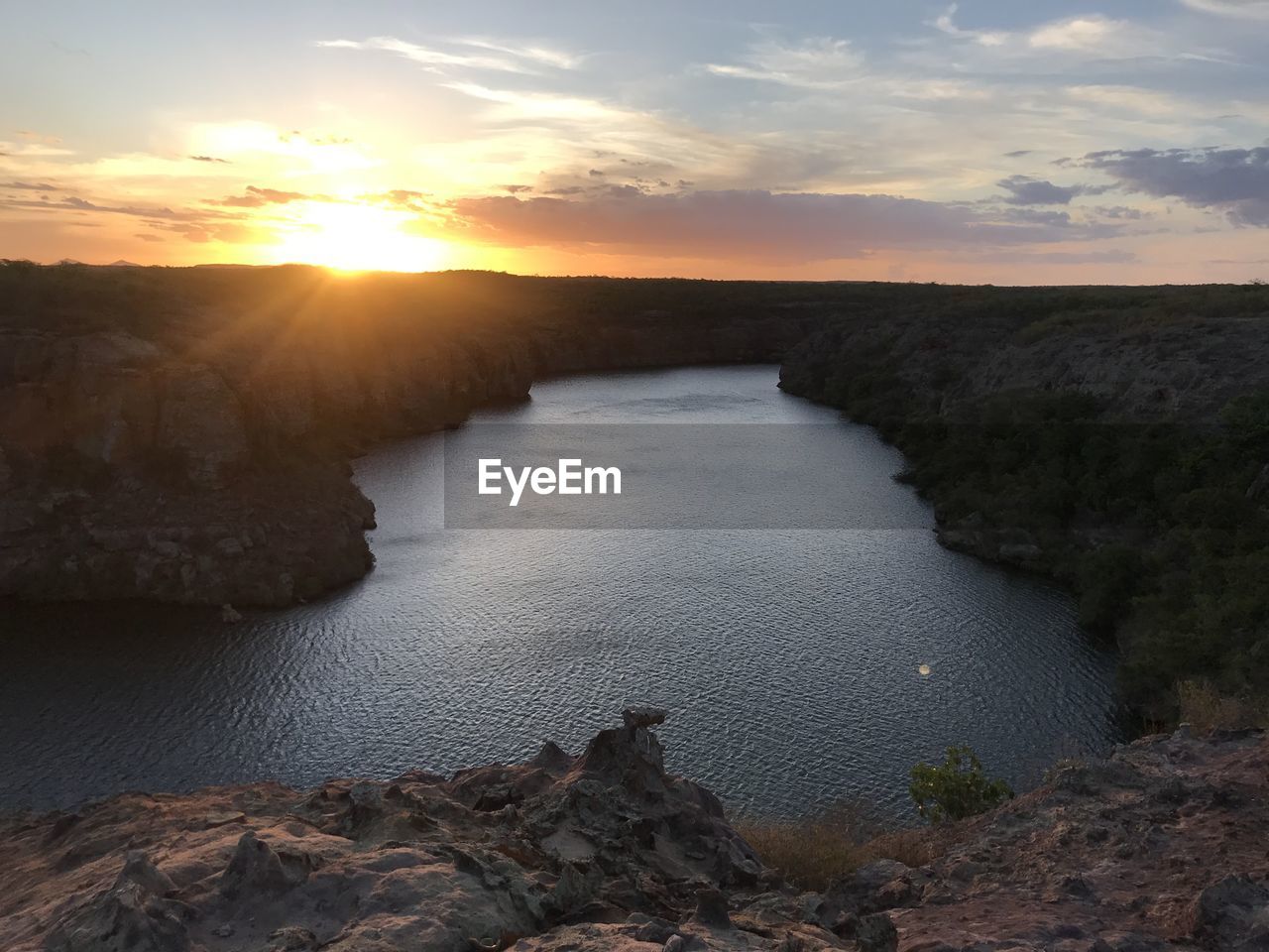 SCENIC VIEW OF ROCKS ON SHORE AGAINST SKY DURING SUNSET