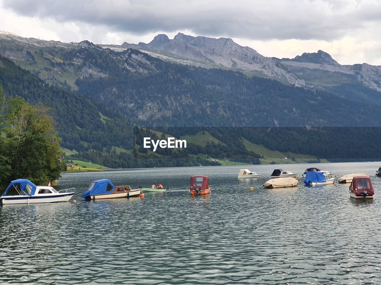 Boats in lake against mountains