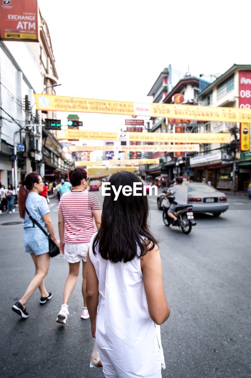 REAR VIEW OF WOMEN WALKING ON STREET