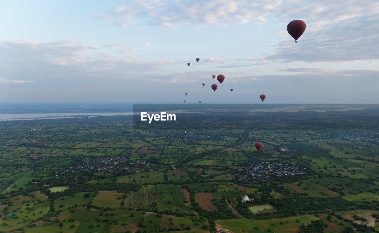 Hot air balloons flying over landscape