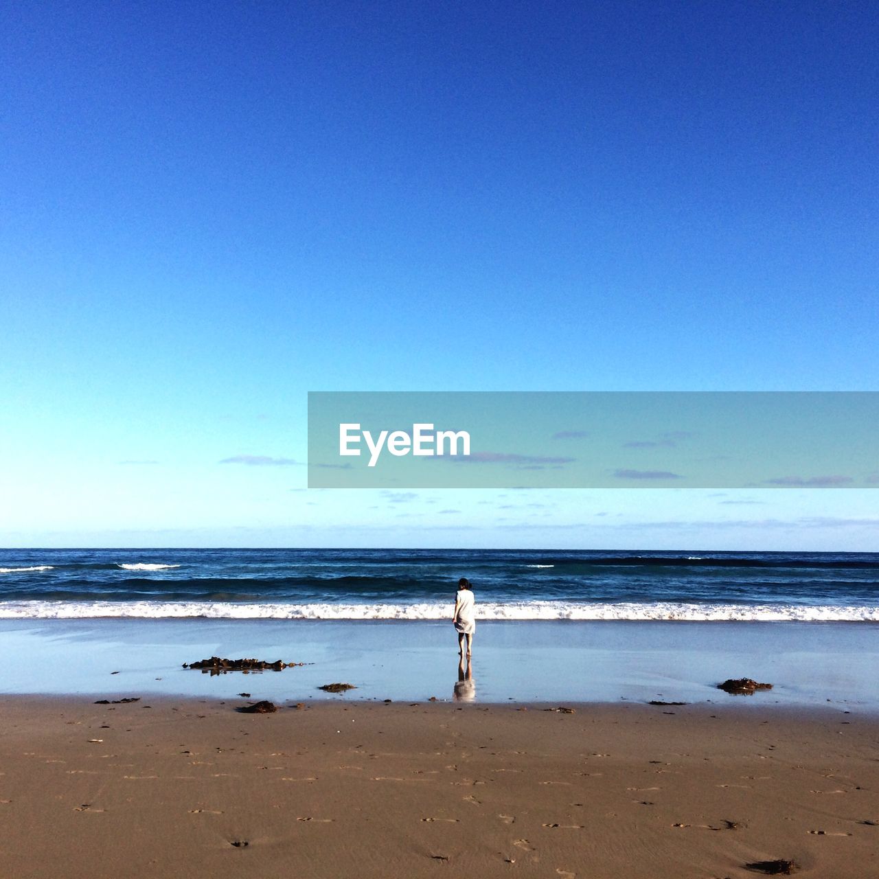 REAR VIEW OF SANDY BEACH AGAINST SKY