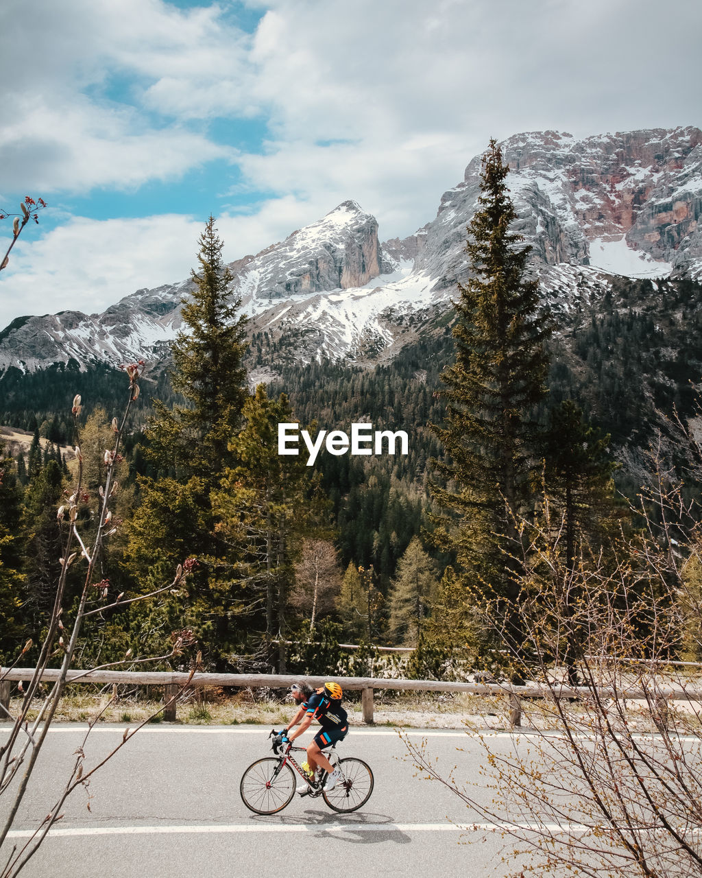 MAN CYCLING ON SNOW COVERED MOUNTAINS