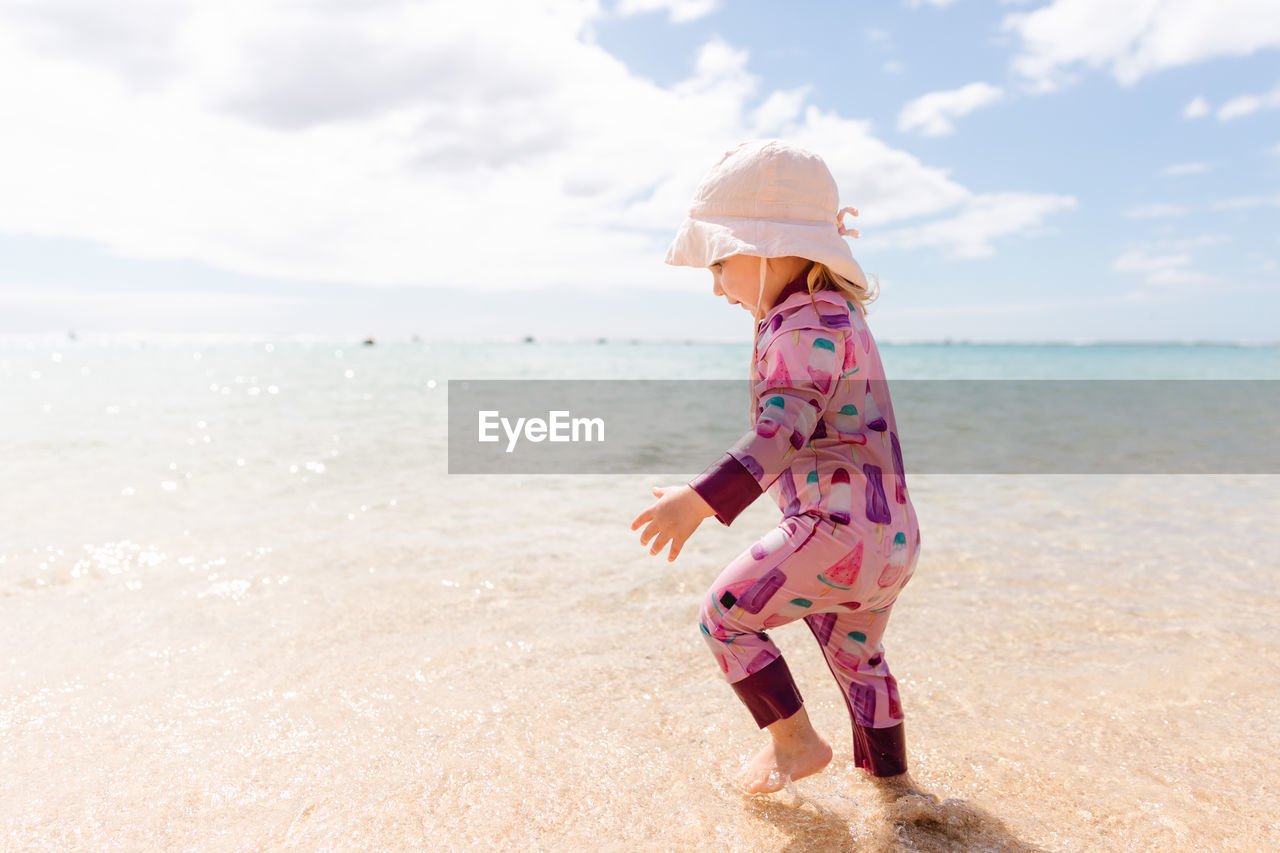 Toddler girl playing in the ocean