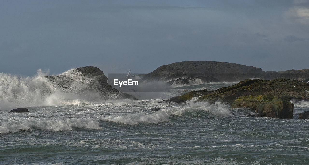 SCENIC VIEW OF SEA WAVES SPLASHING ON ROCKS