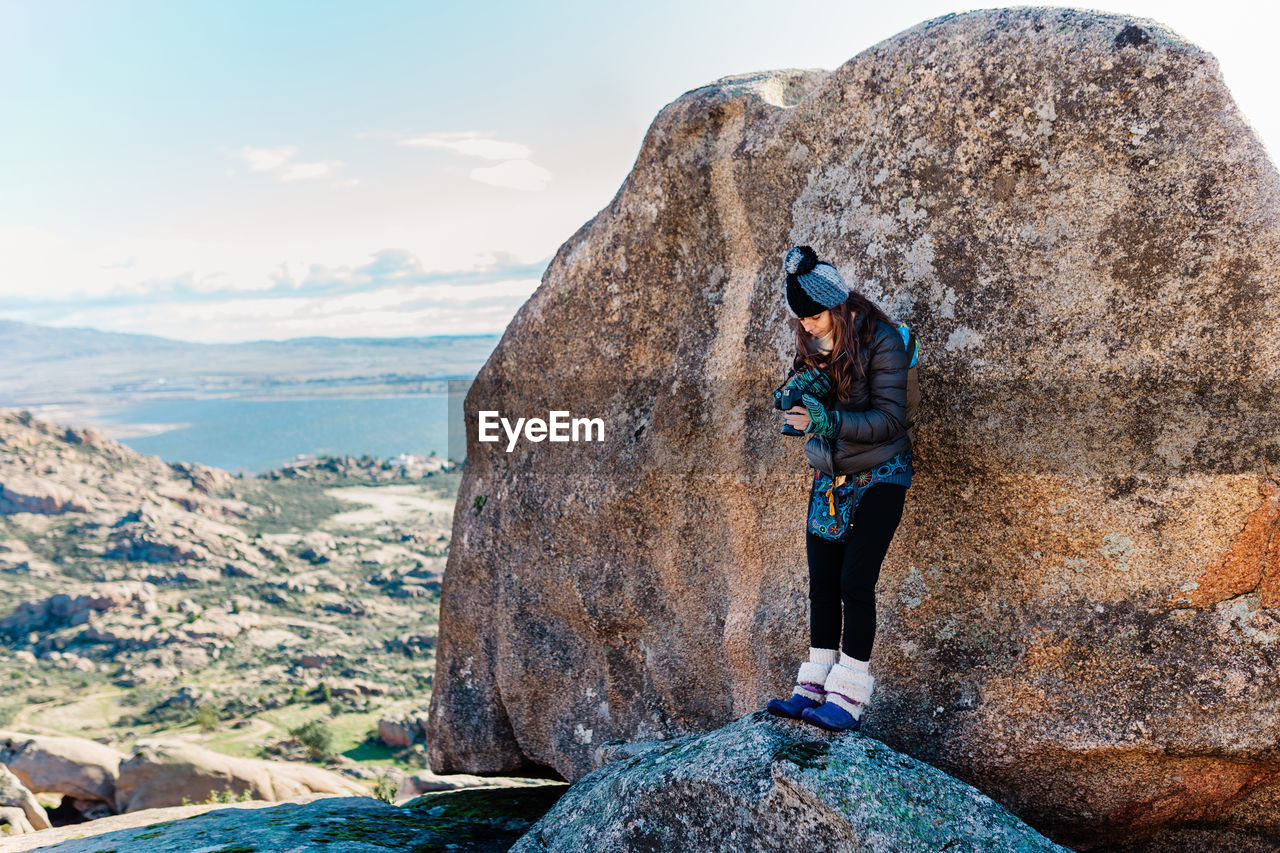 Woman leaning on rock outdoors