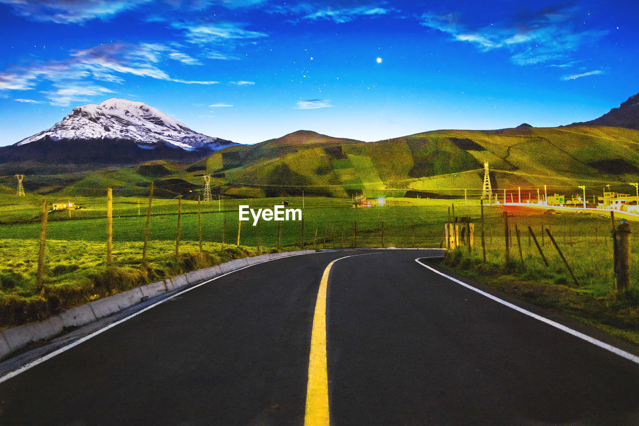 EMPTY ROAD WITH MOUNTAIN RANGE AGAINST SKY