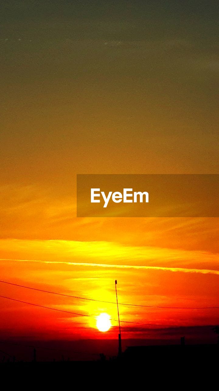 SCENIC VIEW OF DRAMATIC SKY OVER SILHOUETTE LANDSCAPE DURING SUNSET