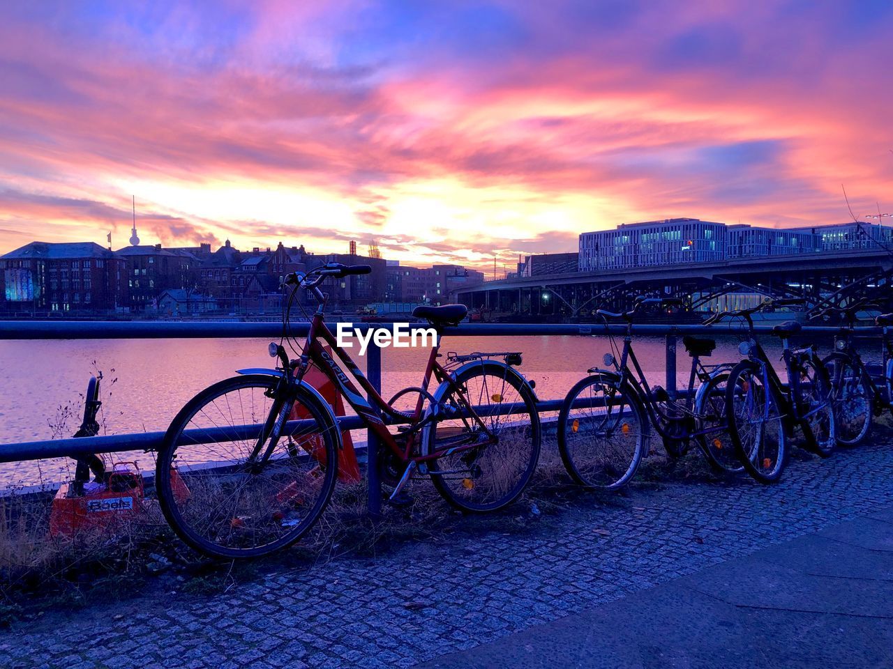 BICYCLES AGAINST RIVER DURING SUNSET