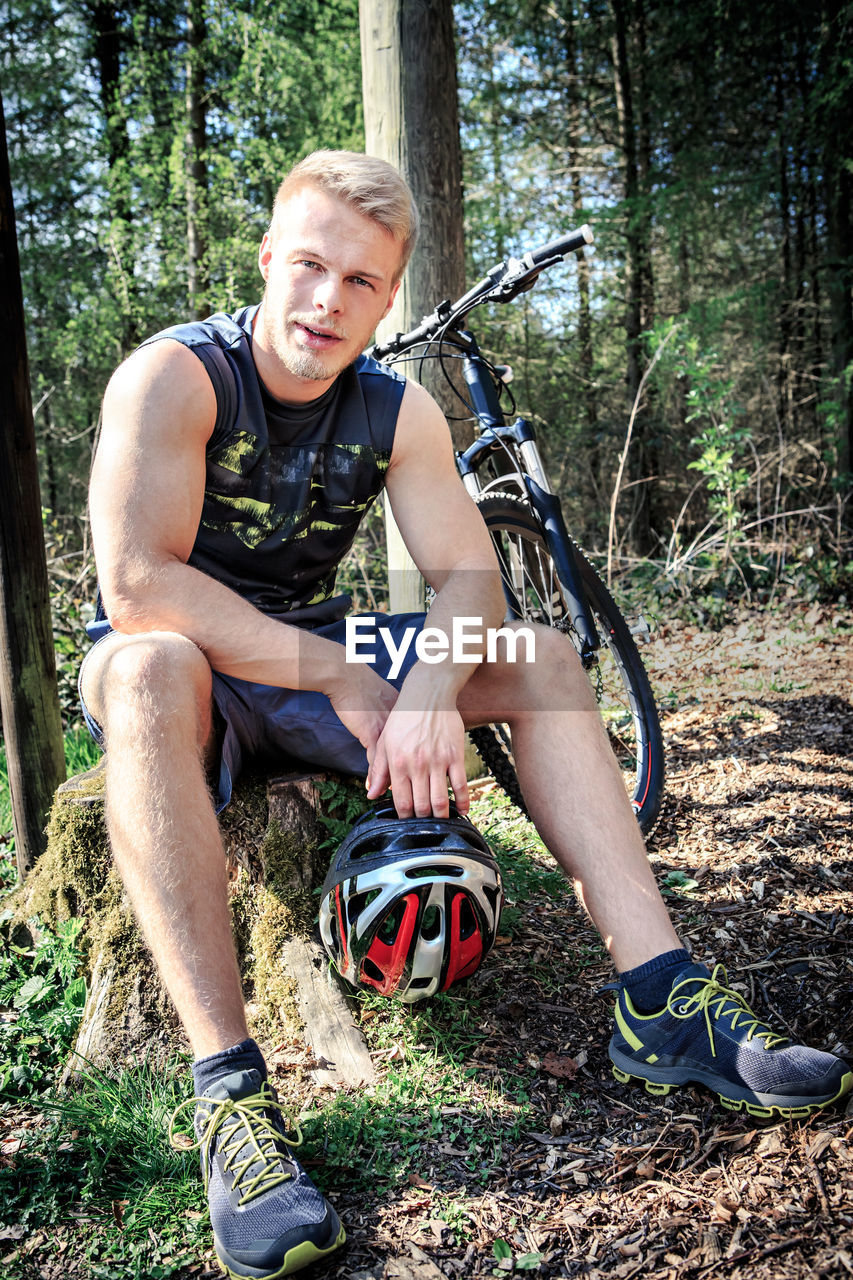 Full length of man with bicycle in forest