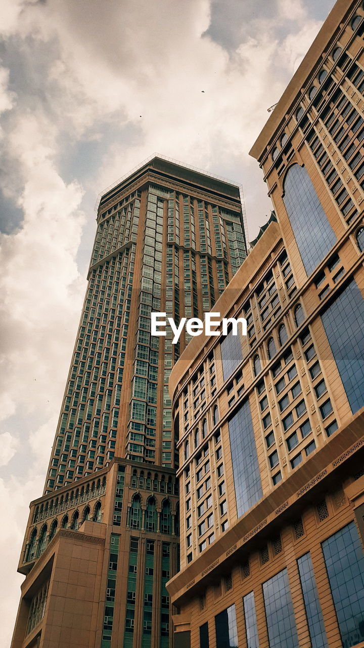 Low angle view of modern building against cloudy sky