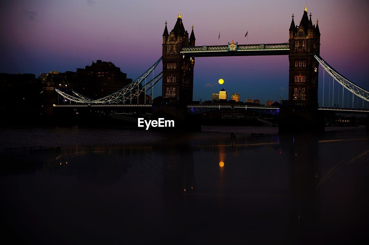 RIVER PASSING THROUGH ILLUMINATED CITY AT NIGHT