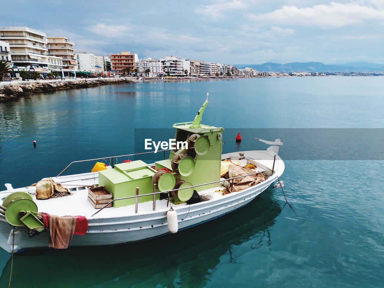 Boats moored in sea against buildings in city