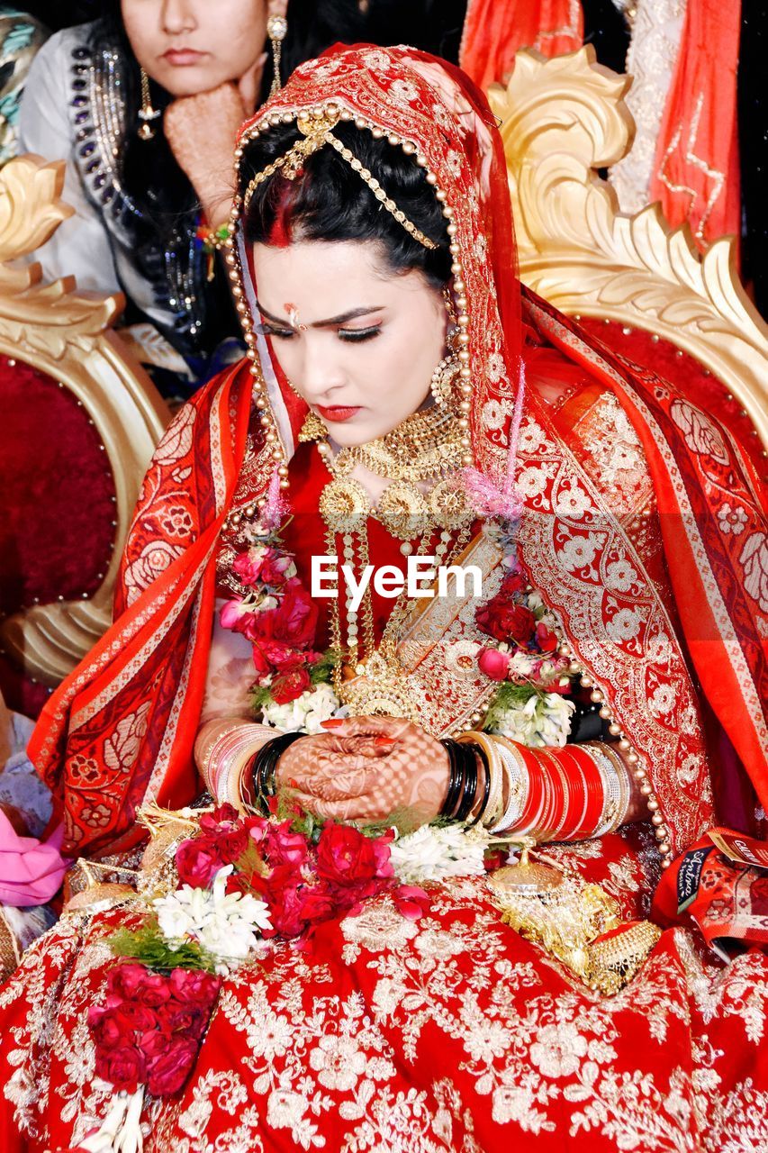 Beautiful woman sitting on seat during wedding