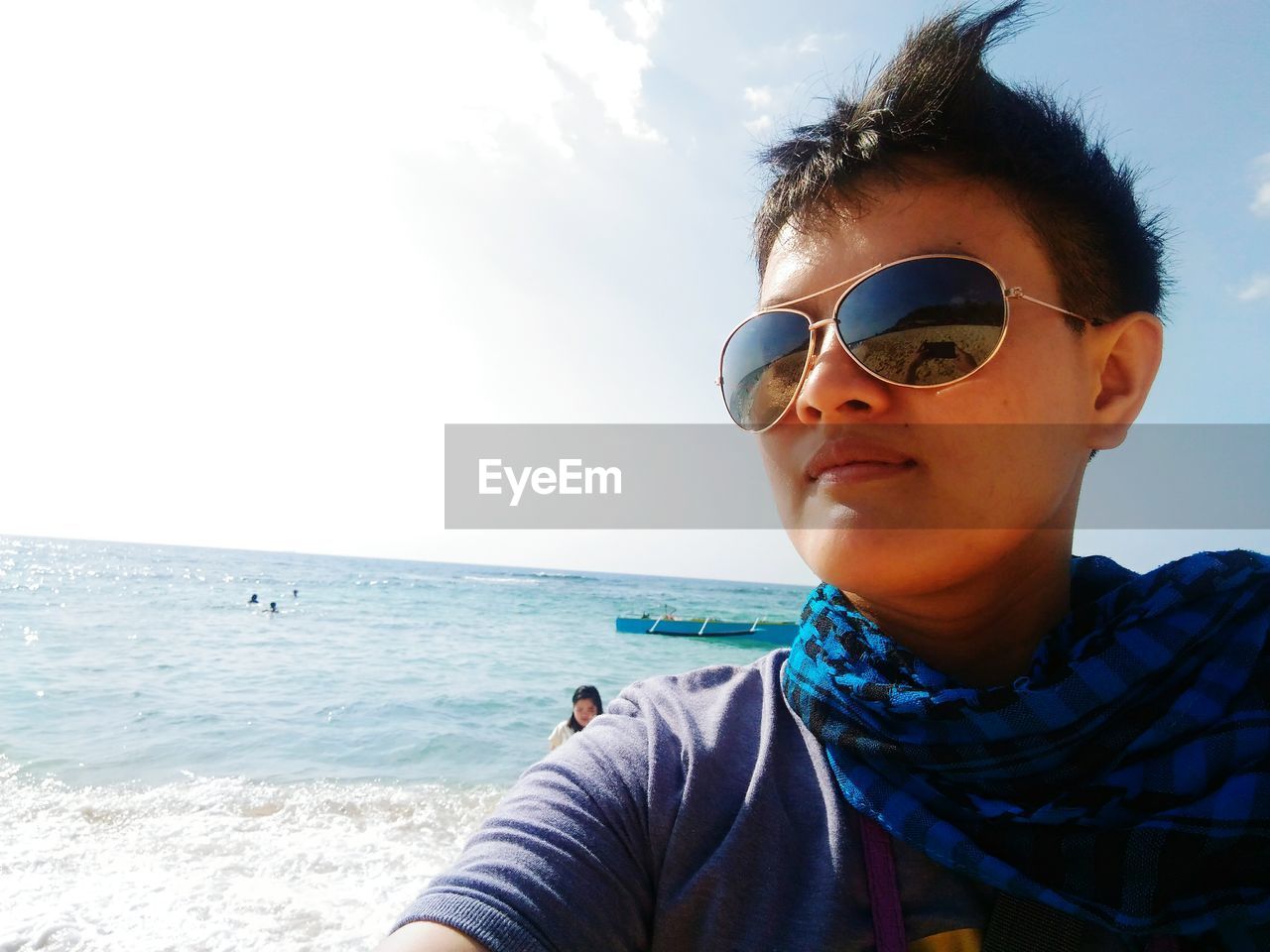 Portrait of woman at beach against sky