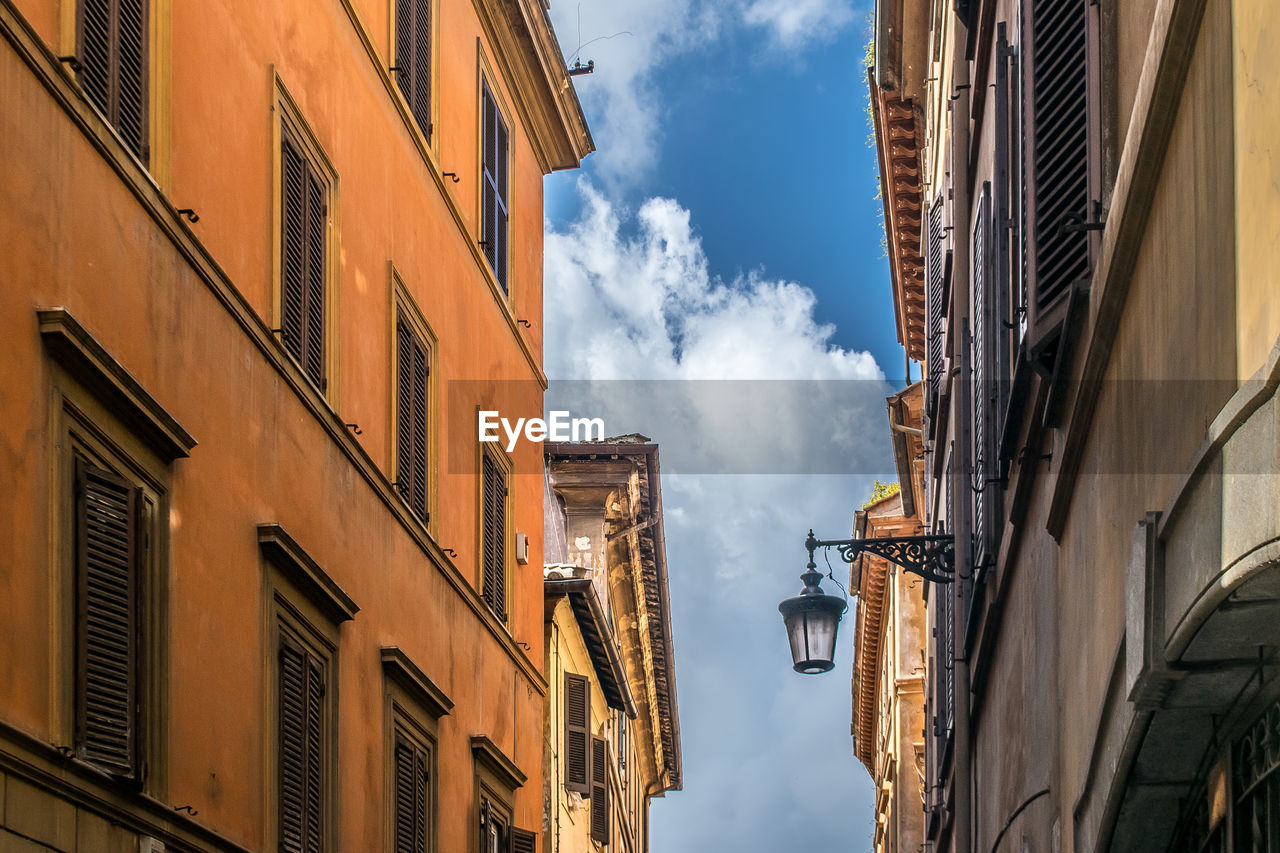 Low angle view of a  narrow alley through the streets and buildings of rome. italy.