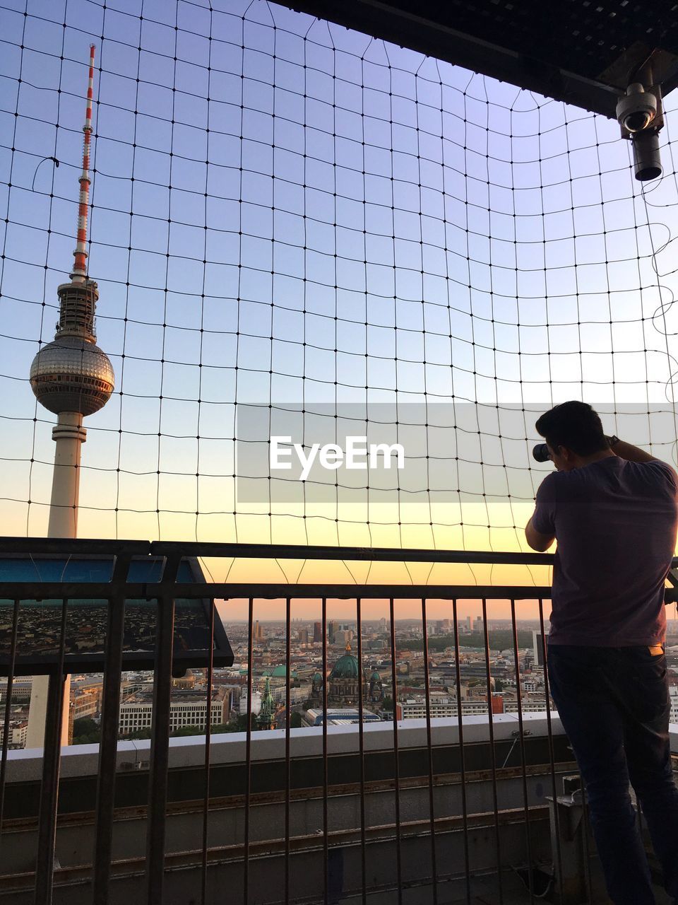 Man photographing cityscape during sunset