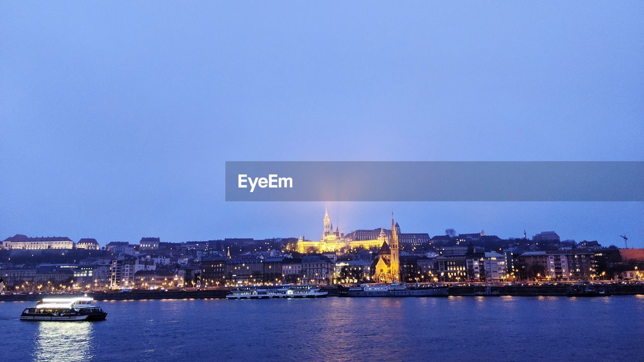 Illuminated buildings in city at waterfront