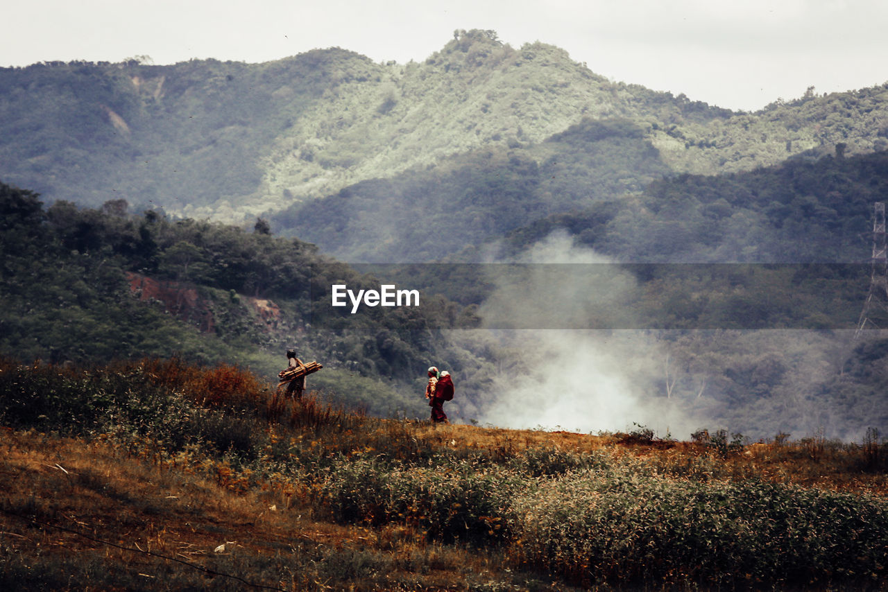 People on land against mountains