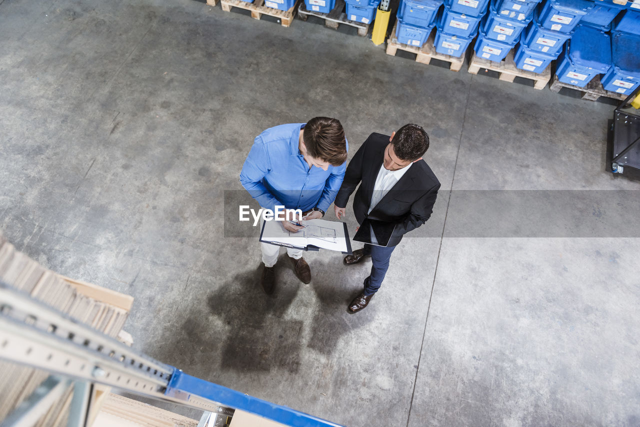 Two businessmen having a meeting in company warehouse