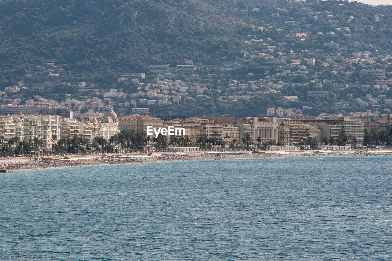 SCENIC VIEW OF SEA AND BUILDINGS IN CITY