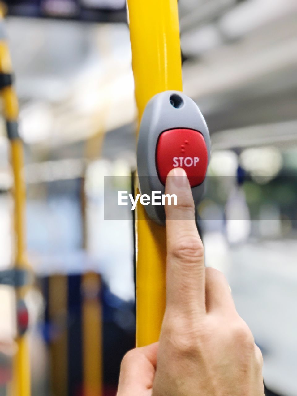 Close up with hand is pressing sign to stop on the bus.